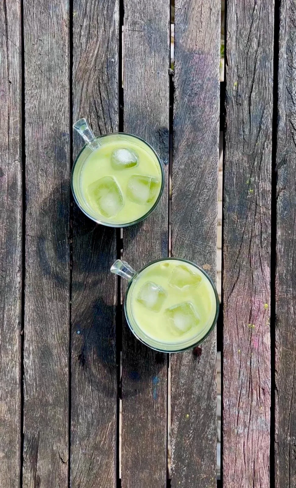 Two iced rooibos lattes on a wooden deck